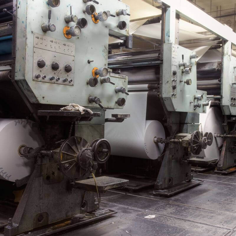 printing press machinery with large rolls of paper