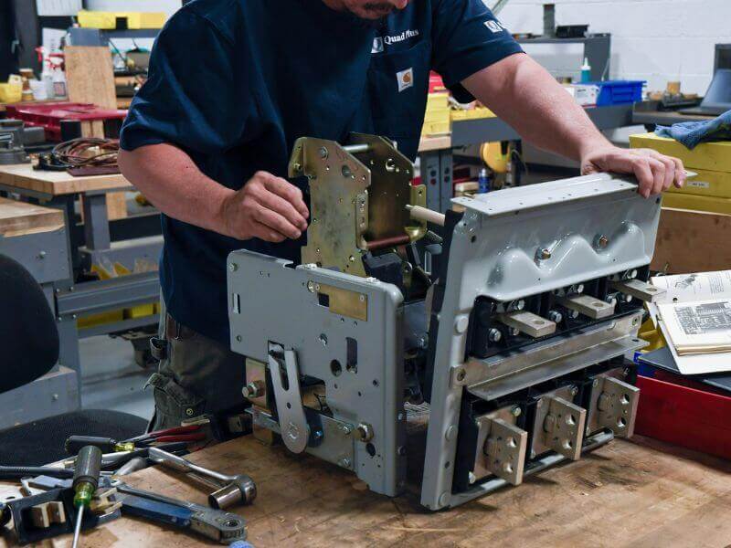 technician is inspecting signs of a bad circuit breaker in a workshop